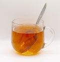 Glass cup with black long leaf tea with a teaspoon