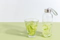 A bottle of cucumber water on a light green background. Minimalistic creative concept. Copy space Royalty Free Stock Photo