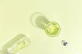 Glass cup with cucumber water on a light green background. Minimalistic creative concept. Copy space