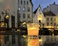 glass cup with candle light on table on medieval street evening blurred bokeh light under rain drops on window in Tallinn old tow Royalty Free Stock Photo