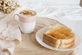 Glass cup with coffee and milk, cappuccino, served with toasted bread with butter on a light background. Royalty Free Stock Photo