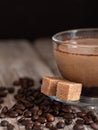 Glass cup with coffee with milk, latte coffee. Cane sugar on a saucer. Coffee beans on a wooden background. Close-up. Vertical Royalty Free Stock Photo