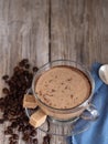 Glass cup with coffee with milk, latte coffee. Cane sugar on a saucer. Coffee beans on a wooden background. Top view. Vertical Royalty Free Stock Photo