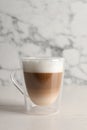Glass cup of delicious layered coffee on white table against marble background, space for text Royalty Free Stock Photo