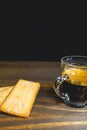 Glass cup of expresso with biscuits on a wooden table Royalty Free Stock Photo