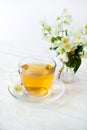 Glass cup of green tea with bouquet of jasmine