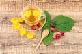 Glass cup of green tea with flowers of calendula and fresh raspberries on wooden background Royalty Free Stock Photo