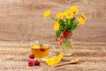 Glass cup of green tea with flowers of calendula and fresh raspberries, fresh bouquet of orange calendula in vase Royalty Free Stock Photo