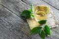 Glass cup of green tea with fresh tea leaves on wooden table Royalty Free Stock Photo