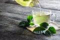 Glass cup of green tea with fresh tea leaves on wooden table Royalty Free Stock Photo