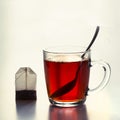 Glass cup of hot black tea and teabag on white. Close up. Royalty Free Stock Photo