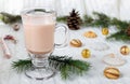 Glass cup of hot cocoa with milk, candies and straw tube on background