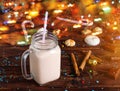 Glass cup of hot cocoa with milk, cinnamon, candies and straw tube