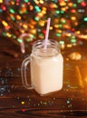 Glass cup of hot cocoa with milk, cinnamon, candies and straw tube