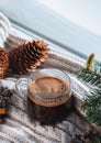 Glass cup of hot espresso coffee, soft knitted warm scarf on the windowsill, winter time. Royalty Free Stock Photo