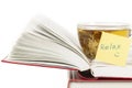 Glass cup with hot herbal tea staying on open pages of book and yellow sticker RELAX on white background macro Royalty Free Stock Photo