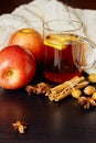 Glass cup of hot spicy drink with apple and orange slices, cinnamon and anise on wooden background Royalty Free Stock Photo