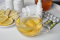 Glass cup of hot tea with lemon and different cold remedies on table Royalty Free Stock Photo