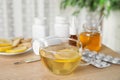 Glass cup of hot tea with lemon and cold remedies on wooden table Royalty Free Stock Photo