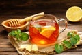 A glass cup of hot tea with lemon, mint, ginger and honey Royalty Free Stock Photo