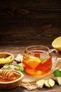 A glass cup of hot tea with lemon, mint, ginger and honey on wooden rustic table. Royalty Free Stock Photo