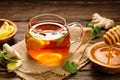 A glass cup of hot tea with lemon, mint, ginger and honey on wooden rustic table. Royalty Free Stock Photo