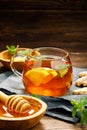 A glass cup of hot tea with lemon, mint, ginger and honey on wooden rustic table. Royalty Free Stock Photo