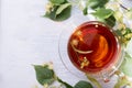 Glass cup of linden tea, and linden flowers on a white wooden table Royalty Free Stock Photo