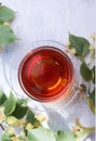 Glass cup of linden tea, and linden flowers on a white wooden table Royalty Free Stock Photo