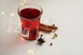 a glass cup of a red warming drink (tea, mulled wine, punch). ingredients for winter hot drinks. glowing lights Royalty Free Stock Photo