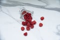 A glass cup with ripe raspberries on the kitchen table