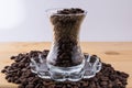 Glass cup on saucer with coffee beans on wooden table Royalty Free Stock Photo