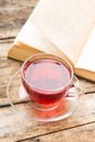 Glass cup of tea with book on table. Reading background Royalty Free Stock Photo