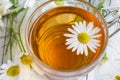 Glass cup of tea with camomile on white wooden background Royalty Free Stock Photo