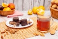 Glass cup of Tea and chocolate cockies on the table with blur orange fruits, closeup shot Royalty Free Stock Photo