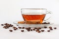 Glass cup of tea with cinnamon sticks and coffee beans. White background. Hot spiced cinnamon tea. Close up Royalty Free Stock Photo