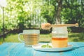 Glass cup of tea with a honey jar on a blue wooden table in a summer garden Royalty Free Stock Photo