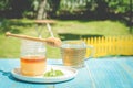 glass cup of tea with a honey jar on a blue wooden table in a summer garden. Copy space Royalty Free Stock Photo