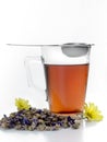 Glass cup with tea inside and a strainer for infusions