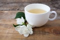 Glass cup of tea with jasmine flowers on wooden background. Royalty Free Stock Photo