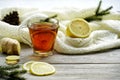 Glass cup of tea with lemon and ginger root slices, mint leaf on glass saucer on a rustic wooden table on background of Royalty Free Stock Photo