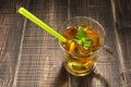 In a glass cup tea with lemon and ice, mint and straw, cold tea Royalty Free Stock Photo