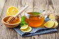 A glass cup of tea with lemon, mint, ginger and honey