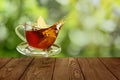 glass cup of tea with splash and slice of lemon on wooden table Royalty Free Stock Photo