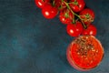 Glass cup with tomato juice with ground black pepper and cherry tomatoes on dark background. top view Royalty Free Stock Photo