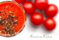 Glass cup with tomato juice with ground black pepper and cherry tomatoes on white background. top view Royalty Free Stock Photo