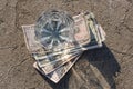 Glass cup with water stands on dollar bills and on dry ground with cracks, concept Royalty Free Stock Photo