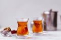 Glass cups of black tea, teapot and sweets Royalty Free Stock Photo