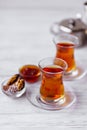 Glass cups of black tea, teapot and sweets Royalty Free Stock Photo