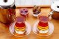 Glass cups of black tea, teapot and sweets Royalty Free Stock Photo
